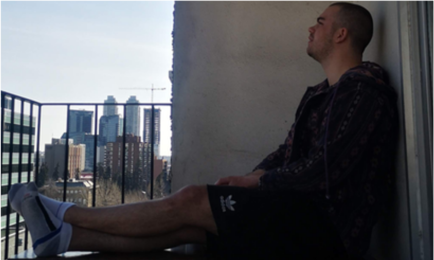 A SeeLocal founder sitting on a Calgary apartment balcony